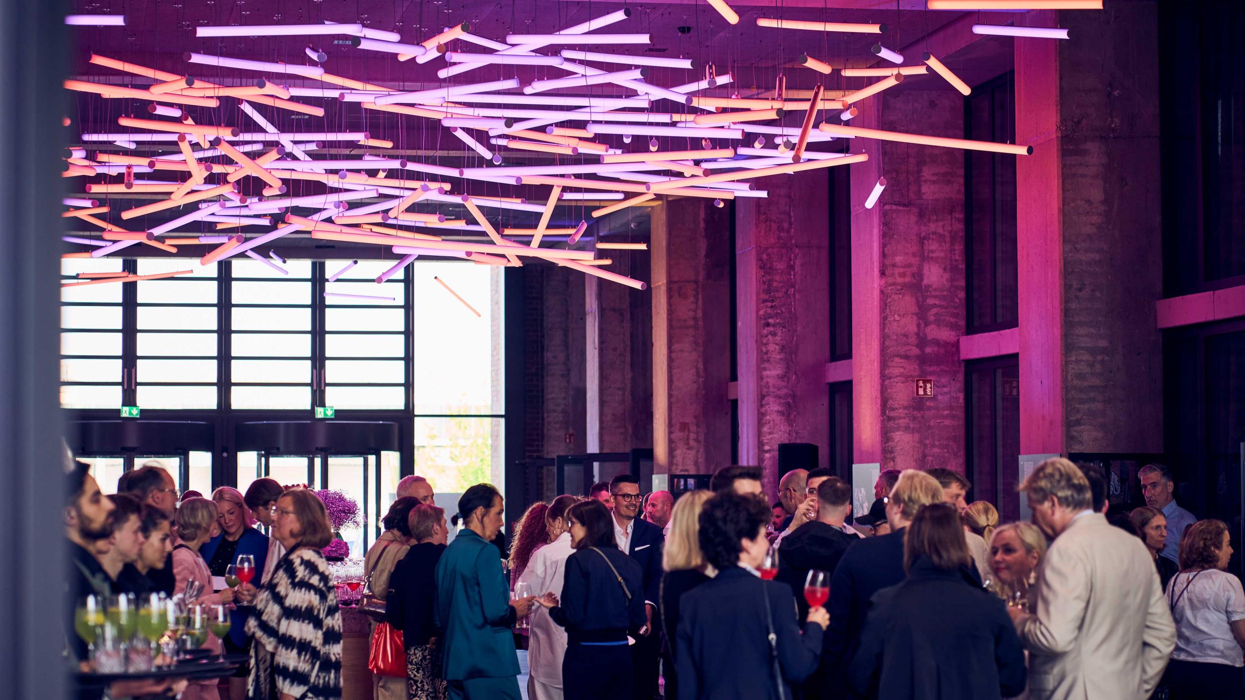 Stimmungsvolle Networking-Atmosphäre unter Lichtkunst im Bergson Atrium