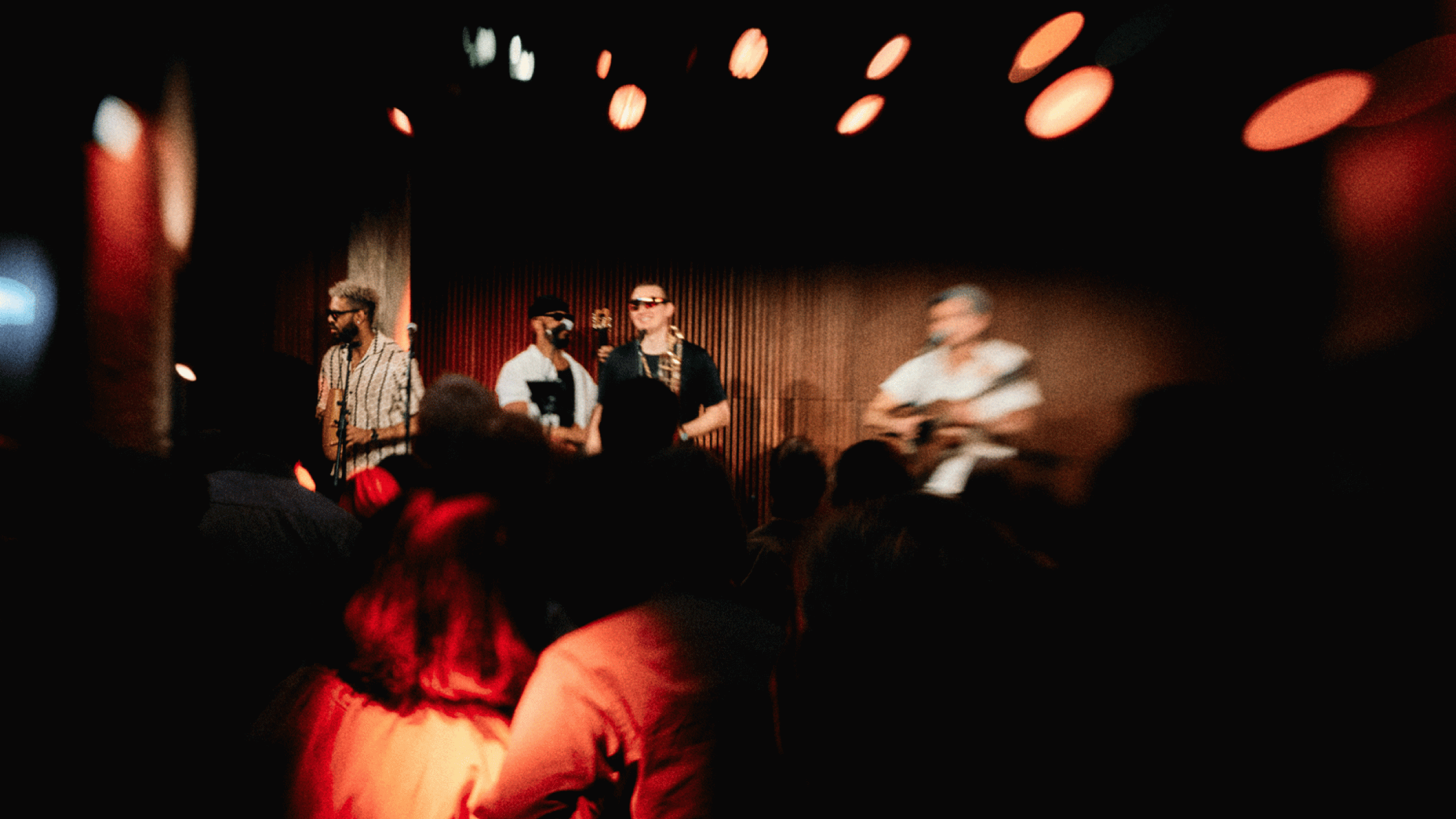 Live-Band bei der Buena Vista Night im Bergson München, Musiker auf der Bühne vor tanzendem Publikum, stimmungsvolle Clubatmosphäre mit warmem Licht und Bewegungsunschärfe