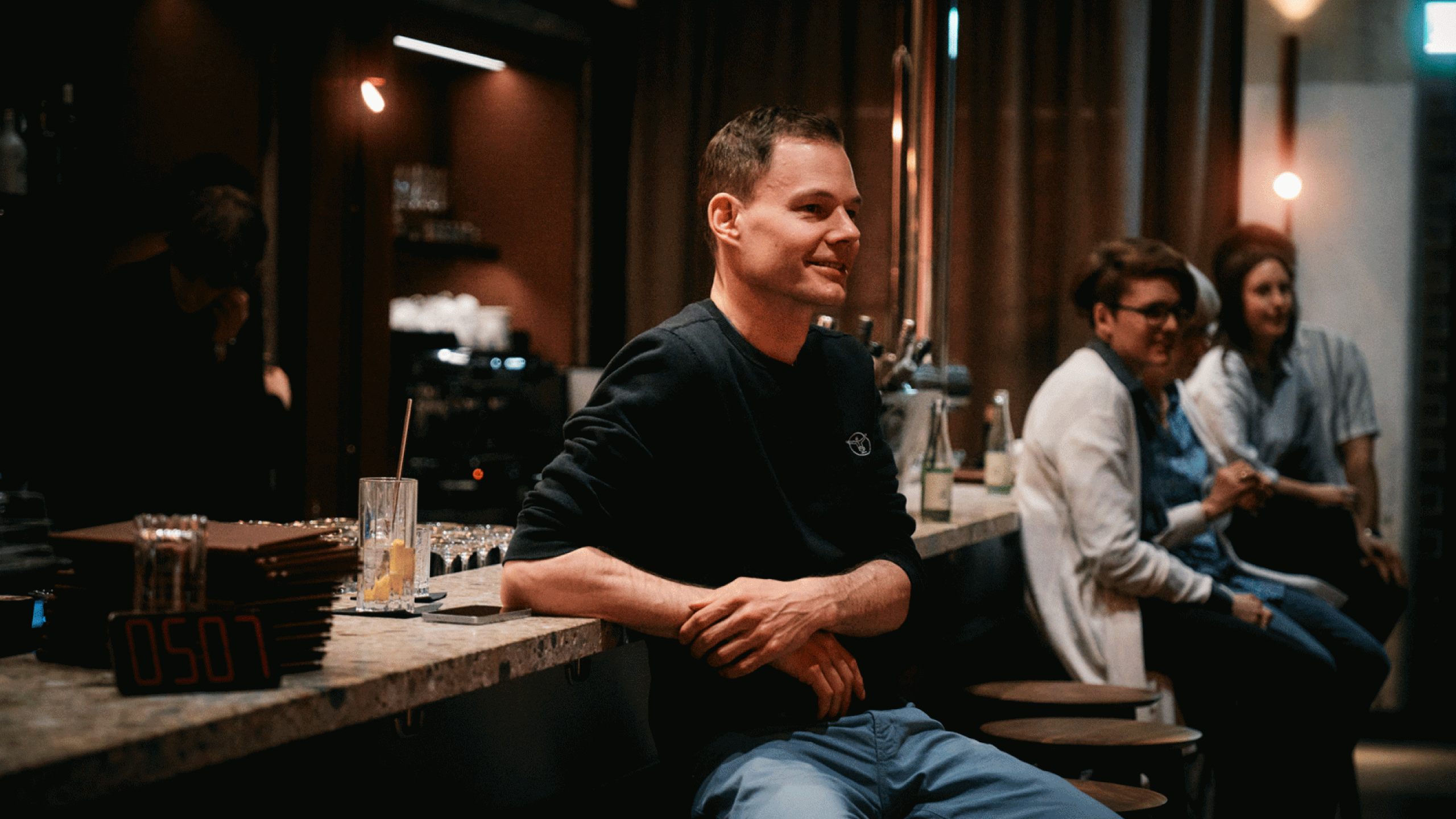 Gast sitzt gut unterhalten an der Theke in der Barbastelle