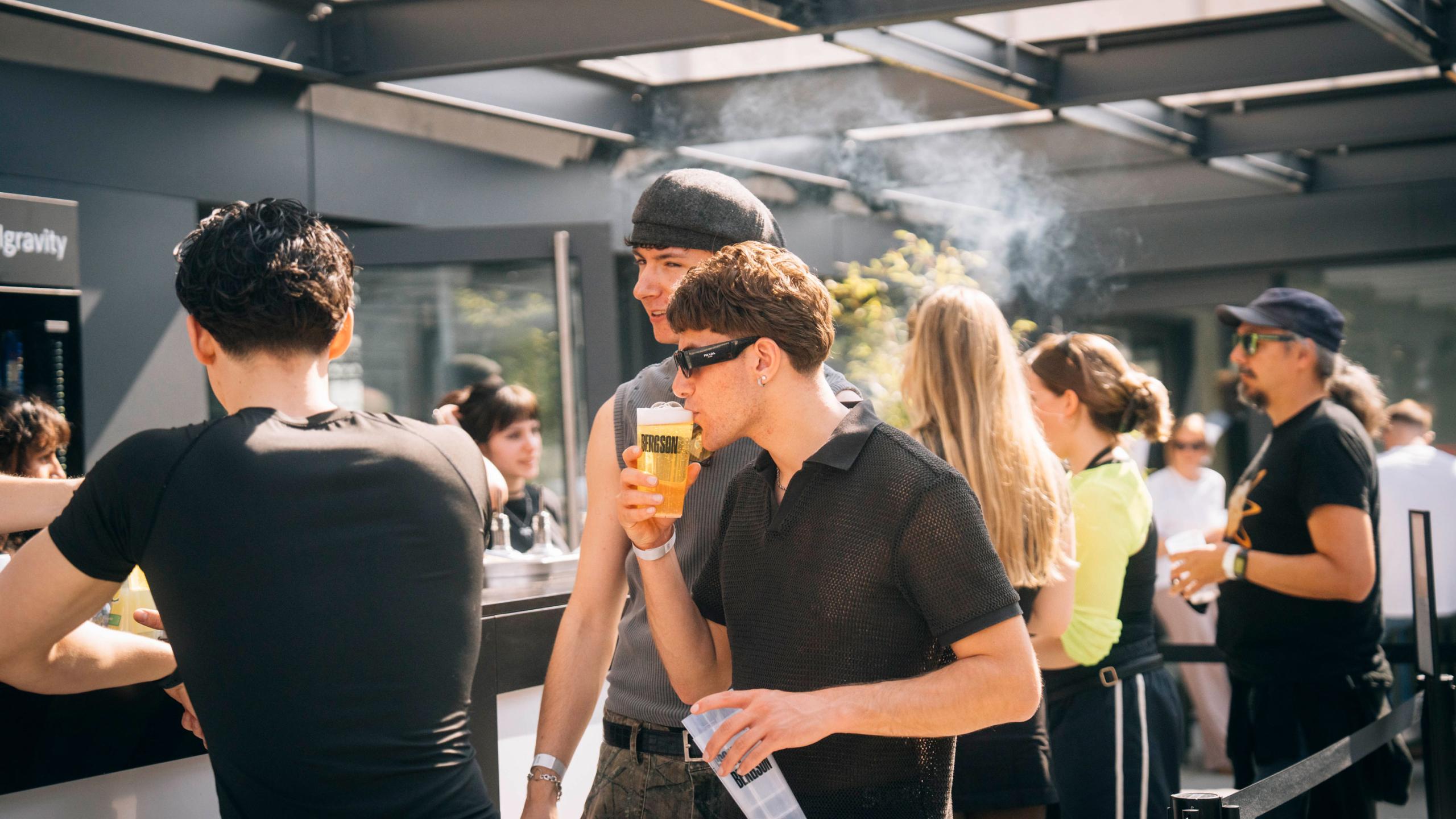 junge Gäste genießen auf der Bergson Dachterasse Drinks