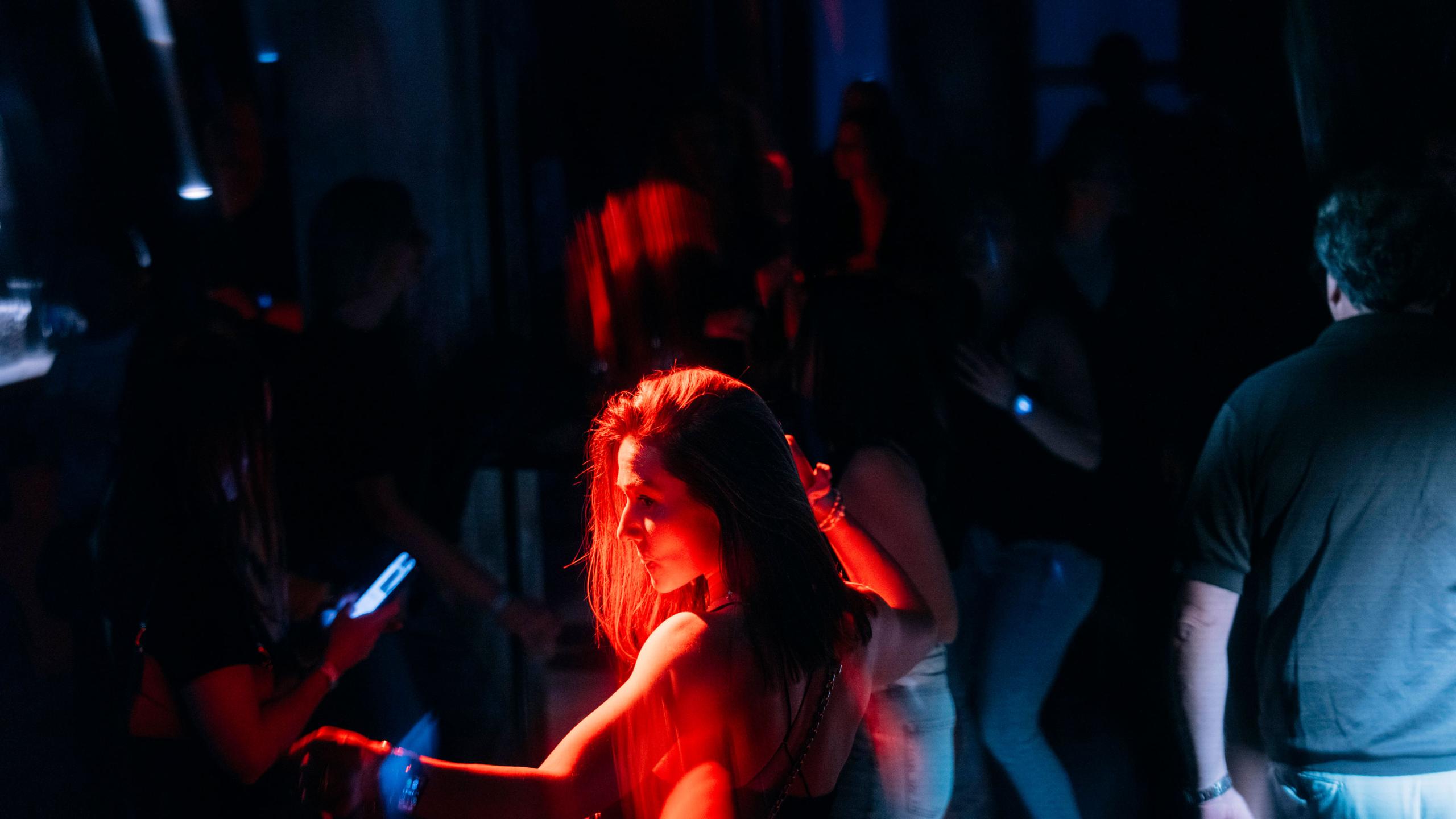 Eine Frau tanzt in rotem und blauem Licht auf einer Party im Bergson